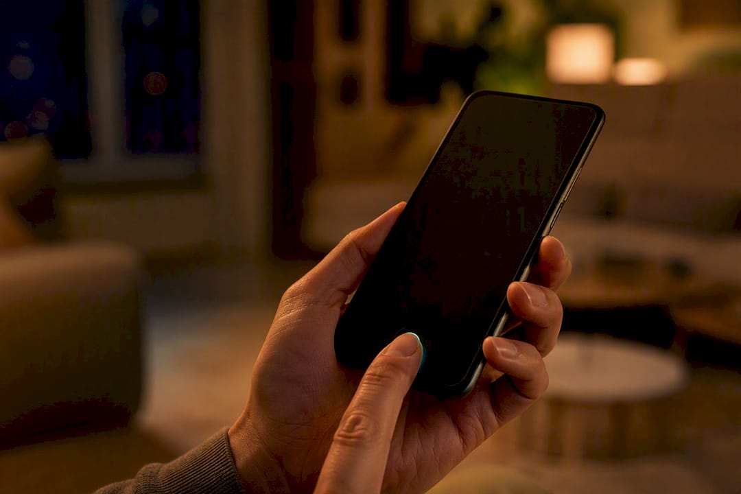 Een hand houdt een smartphone vast om een betaling te bevestigen.