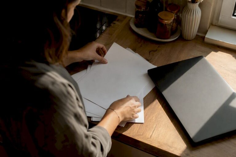 Handen die auditdocumenten op een bureau sorteren